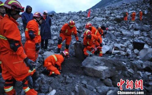  救援人员在挖掘遇难者遗体。 刘忠俊 摄